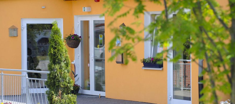 Eingang einer Rehse Einrichtung mit gelber Fassade