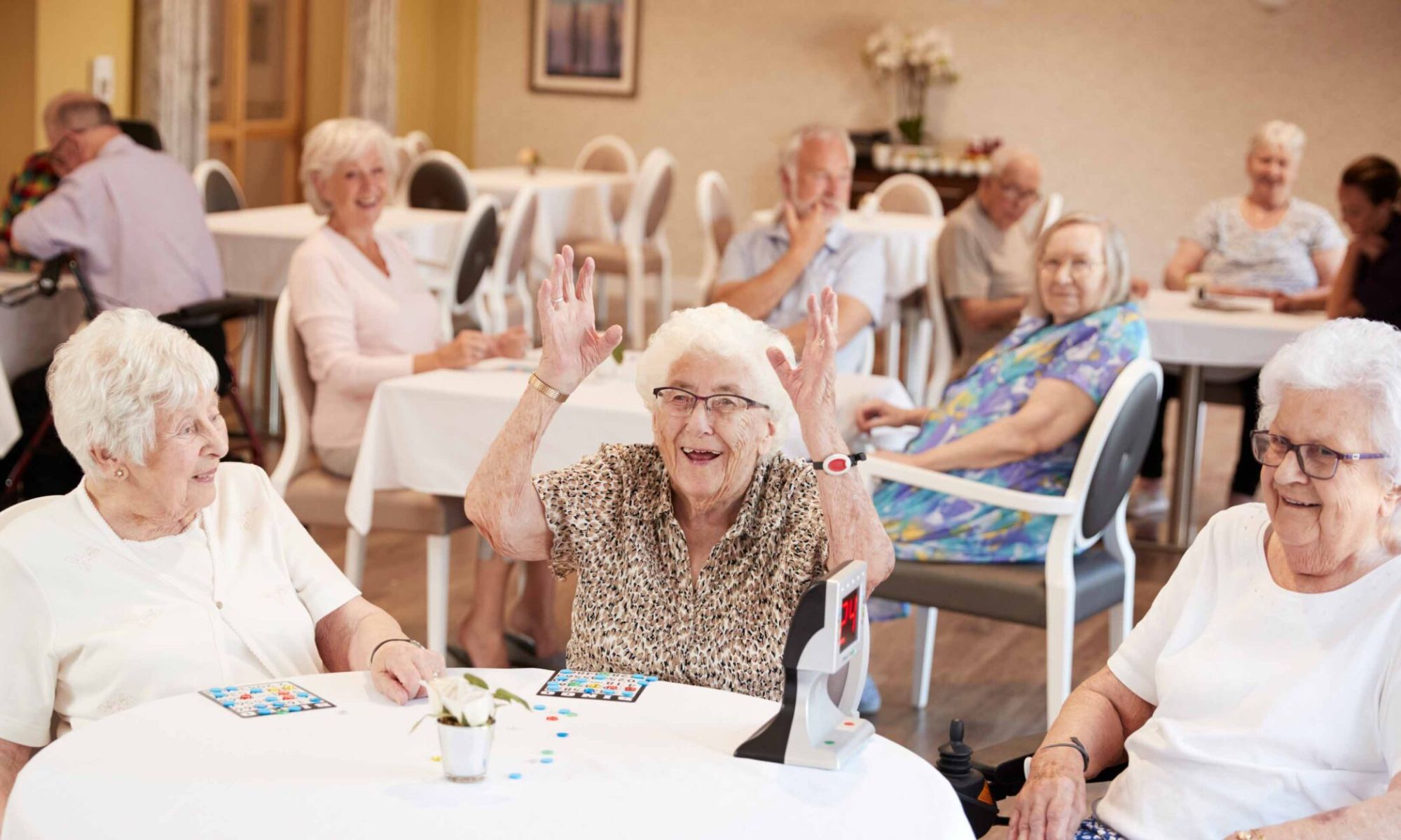Seniorinnen und Senioren sitzen gemeinsam im Aufenthaltsraum